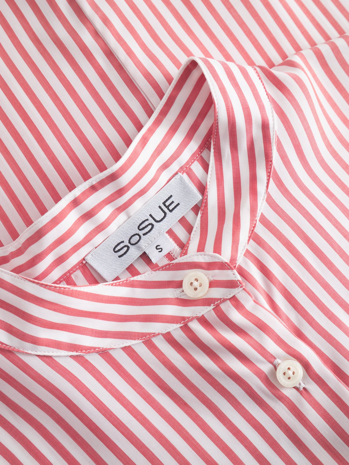 Nahaufnahme des Bluse Antonia Slim Chinese Collar mit roten und weißen Streifen, Knöpfen, einem sichtbaren SOSUE-Markenetikett und einem kleinen S-Größenschild im Kragen.