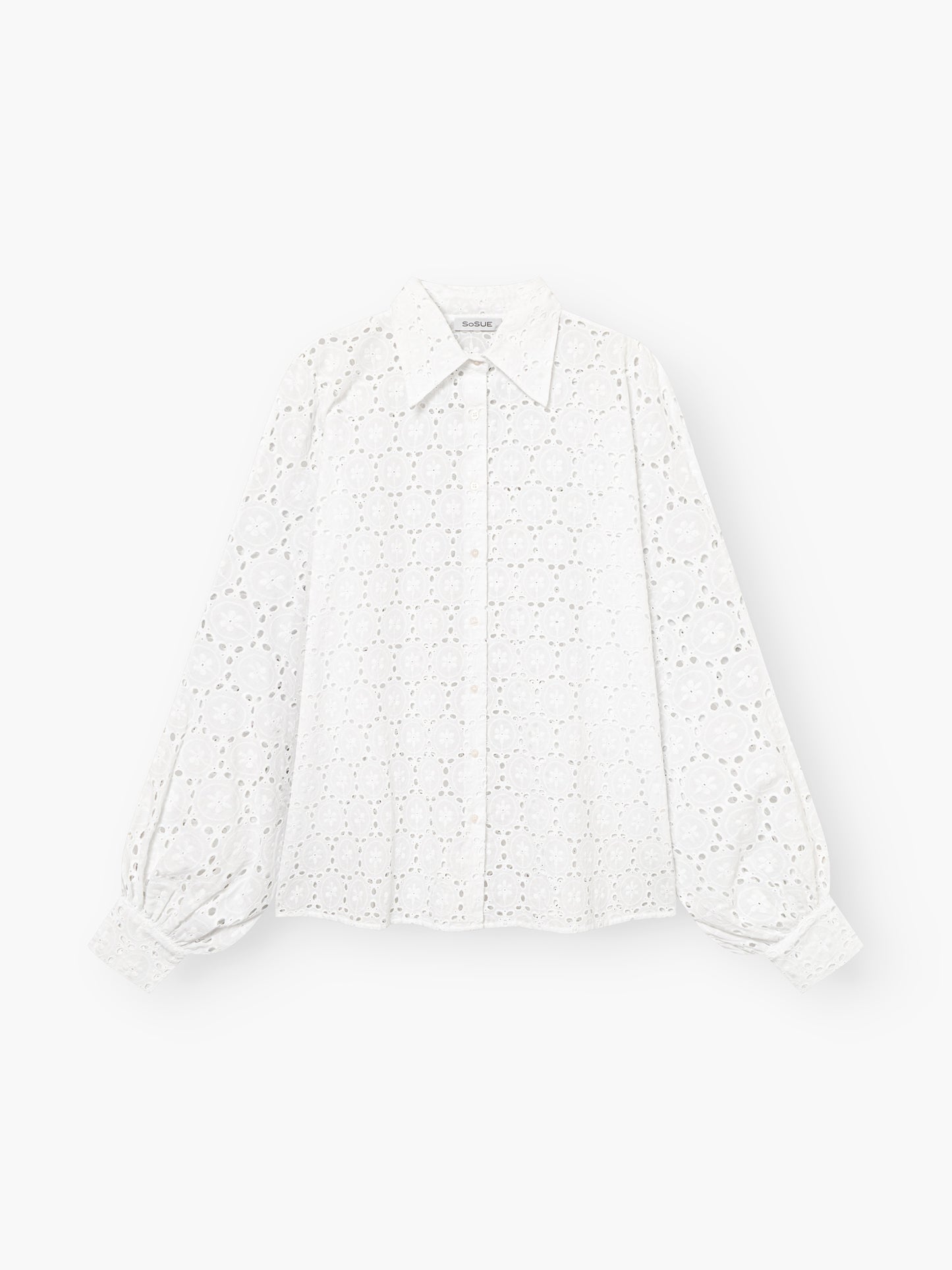 Die Antonia Lace White ist eine weiße, langärmelige Damenbluse aus Broderie Anglaise mit spitzem Kragen, Puffärmeln und geknöpften Manschetten, die auf einem einfarbig weißen Hintergrund gezeigt wird.
