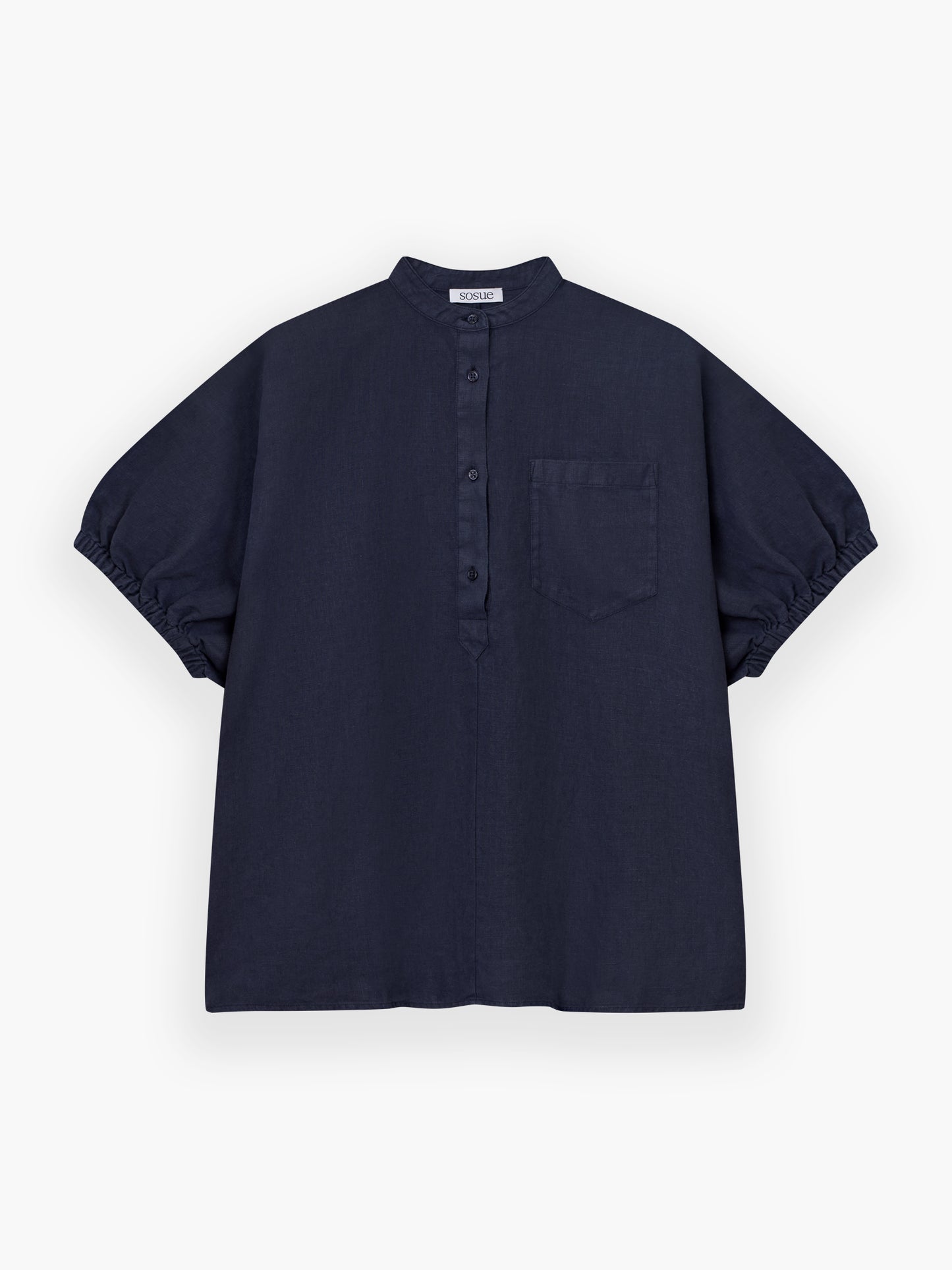 Das Cowboy Button Linen Navy ist ein kurzärmeliges, locker sitzendes marineblaues Hemd mit Mandarinenkragen, Knöpfen vorne, einer Brusttasche und gerafften Ärmeln. Es ist flach auf einem weißen Hintergrund abgebildet.