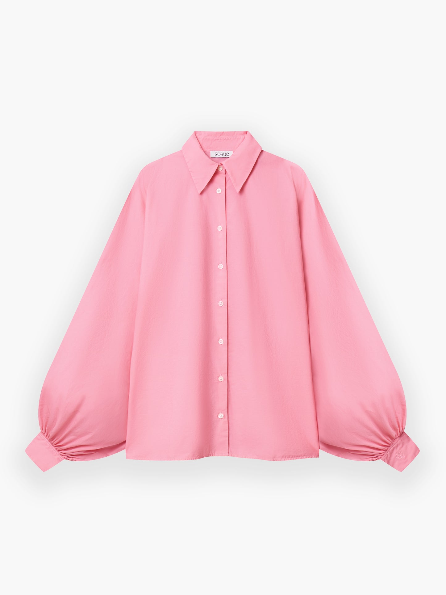 Das Hemd Antonia Cotton Pink hat einen Kragen zum Hochknöpfen, voluminöse geraffte Ärmel, weiße Knöpfe vorne und eine lockere, fließende Passform aus rosa Baumwolle.
