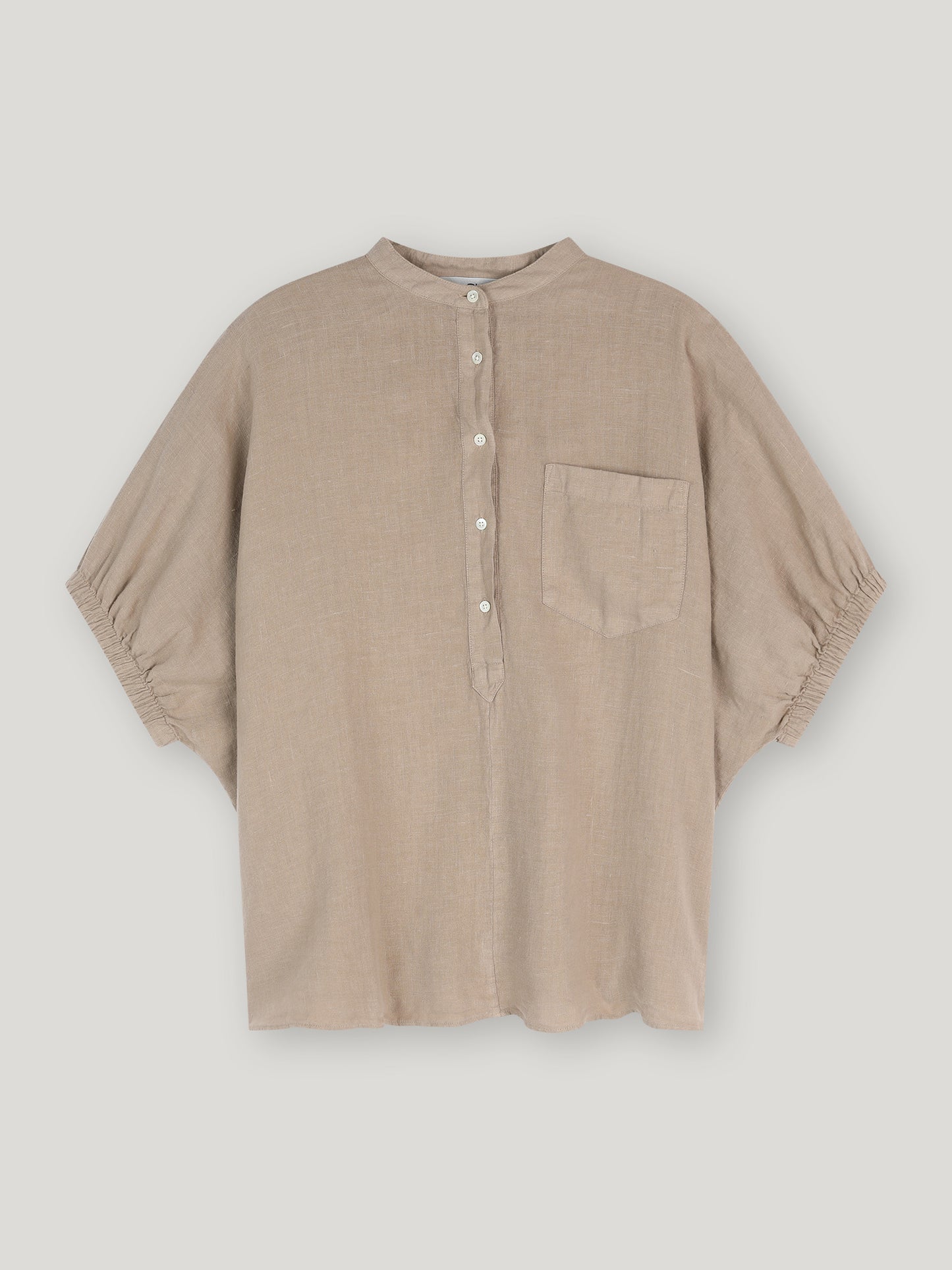 Ein lockeres, beigefarbenes Bluse Cowboy Button Leinenhemd mit Stehkragen, halber Knopfleiste und weißen Knöpfen, kurzen Ärmeln mit gerafften Manschetten und einer Brusttasche - auf weißem Grund abgebildet.