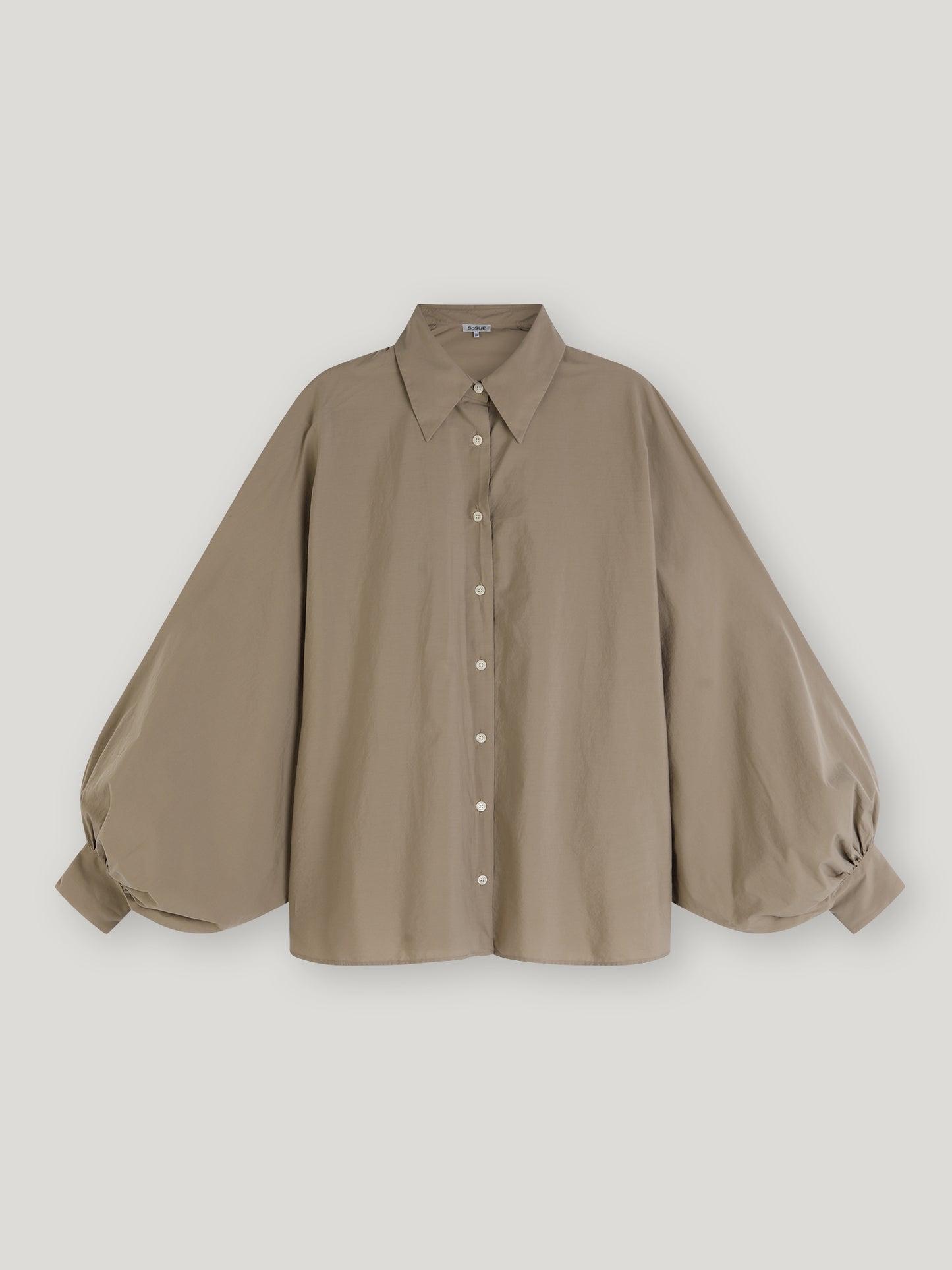 Bluse Antonia Mud: Locker sitzende Damenbluse in Hellgraubeige mit Oversized-Schnitt, spitzem Kragen, Knopfleiste und voluminösen Ballonärmeln mit Manschetten. Das leichte Material sorgt für Komfort und modernen Stil.