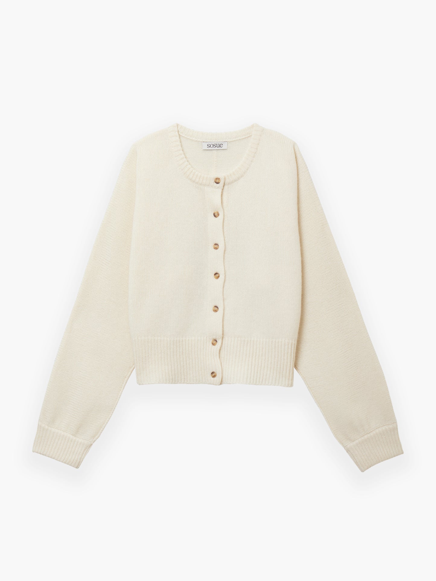 Die Jacke Cashmere OffWhite ist eine cremefarbene, langärmelige Strickjacke mit Rundhalsausschnitt, Rippbündchen an Ärmeln und Saum und Knopfverschluss vorne mit kleinen runden Knöpfen.