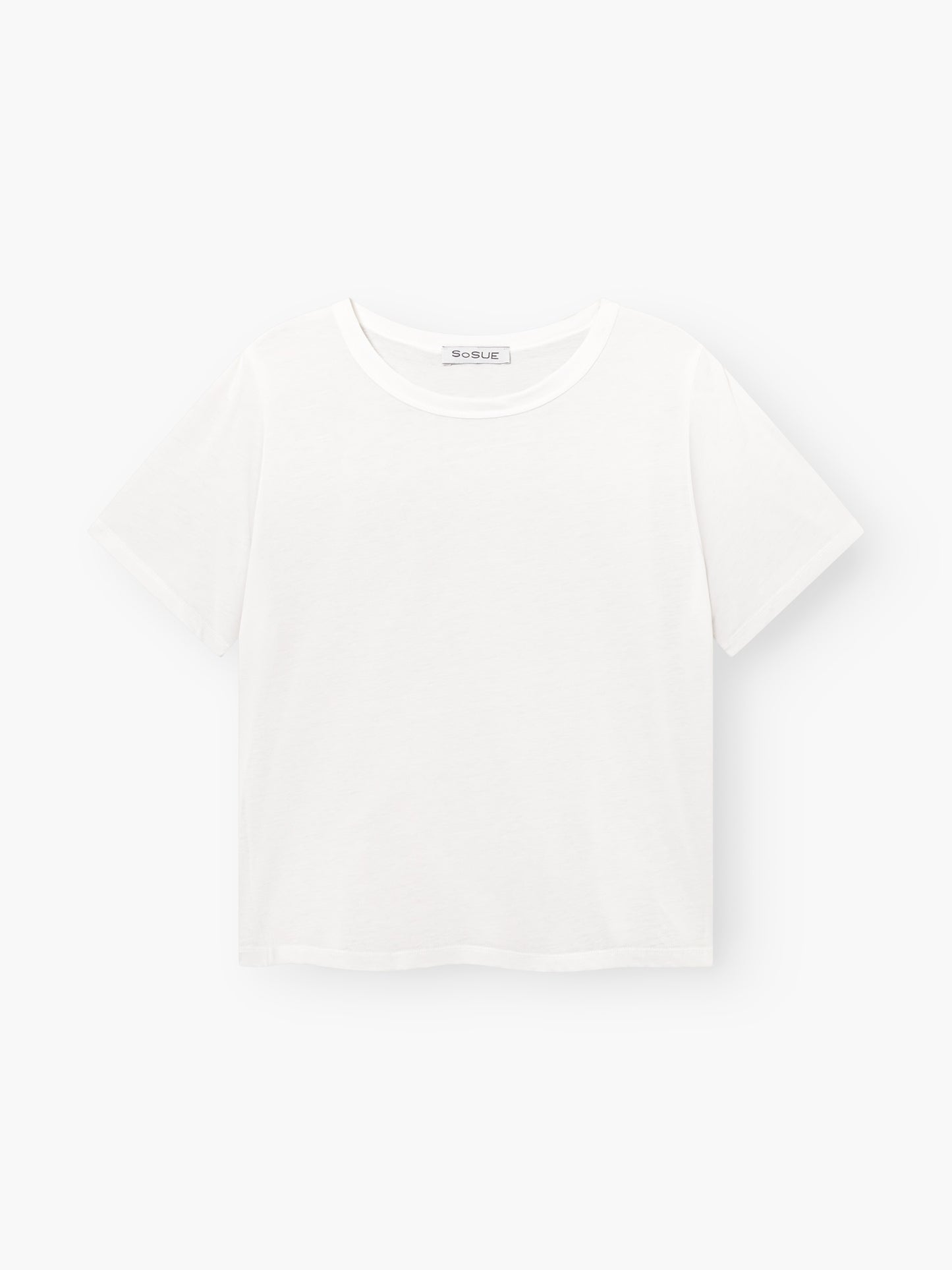 Das T-Shirt Cropped White hat kurze Ärmel und einen Rundhalsausschnitt. Es wird vor einem hellen Hintergrund präsentiert und hängt flach.