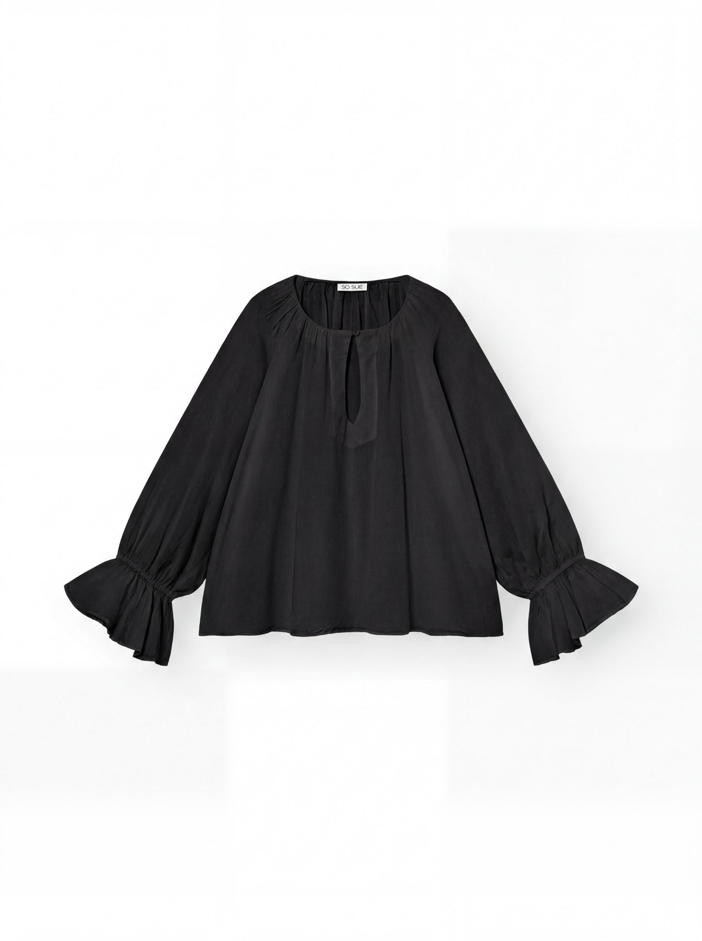 Die Bluse Carmen Black ist eine locker sitzende Bluse aus schwarzem Baumwoll-Voile mit langen, weiten Ärmeln, gerafften Manschetten, einem gerafften Ausschnitt und einem kleinen Schlüsselloch auf der Vorderseite - ideal für ein luftiges Sommeroutfit auf einem schlichten weißen Hintergrund.