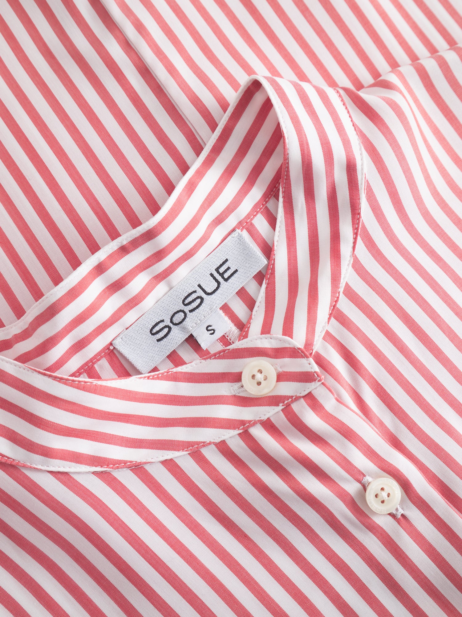 Nahaufnahme des Bluse Antonia Slim Chinese Collar mit roten und weißen Streifen, Knöpfen, einem sichtbaren SOSUE-Markenetikett und einem kleinen S-Größenschild im Kragen.