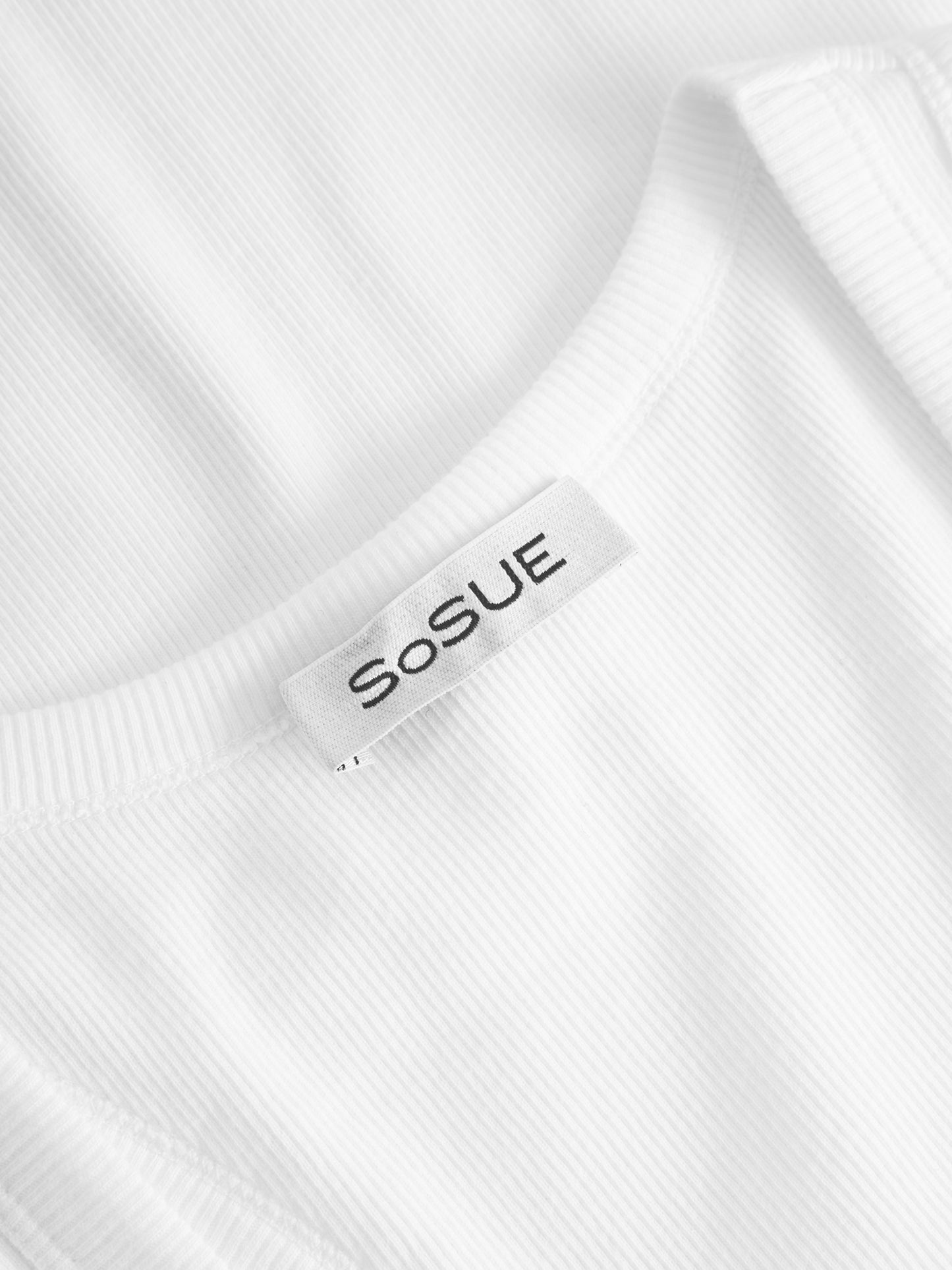 Nahaufnahme des Tank Top Rip White, ein weißes geripptes Damen-Tank-Top aus Baumwolle mit eingenähtem "SoSUE"-Schild, das für nachhaltige Damenmode steht.