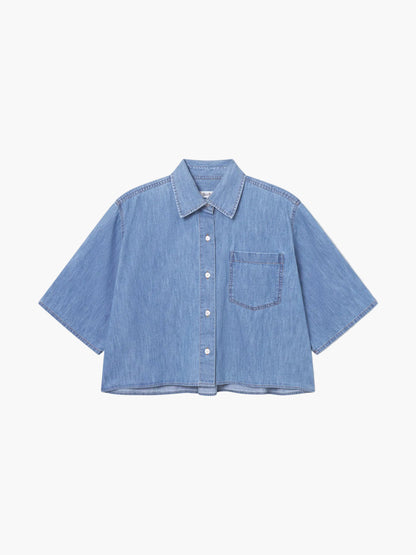 Die Bluse Short Sleeve Denim ist ein hellblaues, kurzärmeliges Denim-Top mit Brusttasche und klassischem Kragen, perfekt als Damenbluse Blau. Diese kurz geschnittene Jeansbluse hebt sich auf einem schlichten weißen Hintergrund ab und sorgt für einen frischen, modernen Stil.