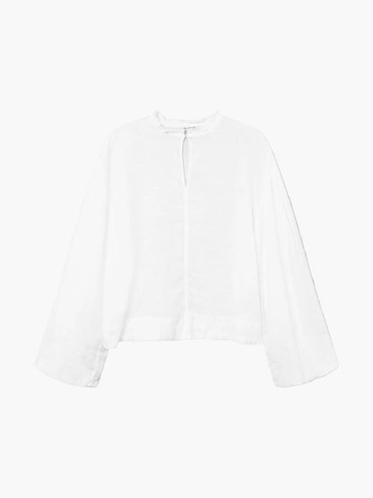 Die Bluse Top Antonia Linen ist eine weiße Leinenbluse mit lockerem, weitem Schnitt, voluminösen Ärmeln sowie Keyhole-Ausschnitt und kleinem Knopfverschluss am Hals.