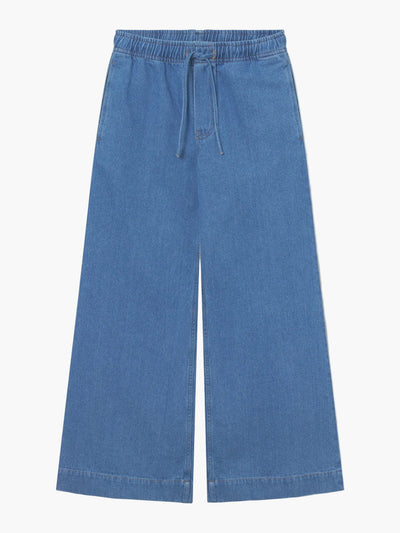Wir stellen die Hose Anna Blue vor: Weit geschnittene Damenhose aus Denim in Jeansoptik mit elastischem Bund, Kordelzug und Seitentaschen - für stilvollen Komfort, auf weißem Hintergrund präsentiert.