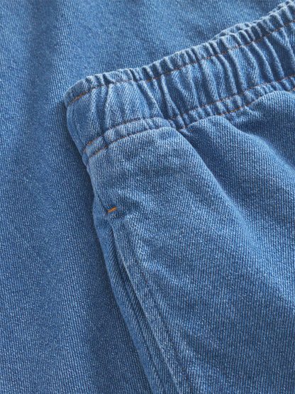 Die Nahaufnahme des Jeansstoffs der Pants Anna Blue zeigt den elastischen Bund, die Tasche, die sichtbaren Nähte, die strukturierten Details und die trendige Jeansoptik.