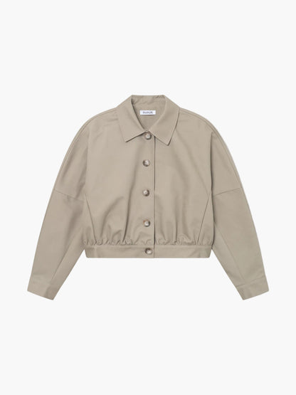 Ein beigefarbener, langärmeliger Trench-Bomber mit Kragen und elastischem Saum wird auf weißem Grund gezeigt. Sein minimalistisches Design macht ihn ideal für nachhaltige Mode Damen, die stilvolle Schlichtheit suchen.