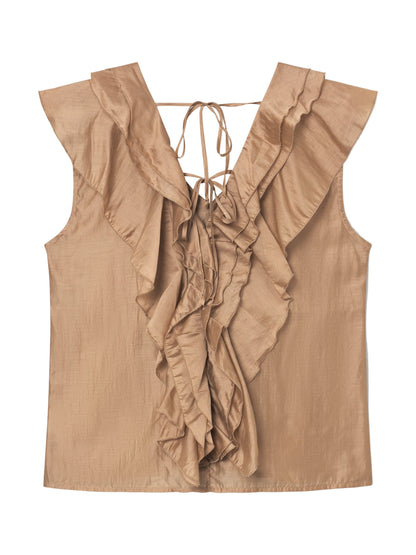 Das Top Ruffle Gold ist eine ärmellose Bluse in Hellbraun mit tiefem V-Ausschnitt, Rüschendetails vorne und hinten und zarten Nackenbändern. Der subtil glänzende Stoff bietet ein weiches, fließendes Gefühl für zusätzliche Eleganz.