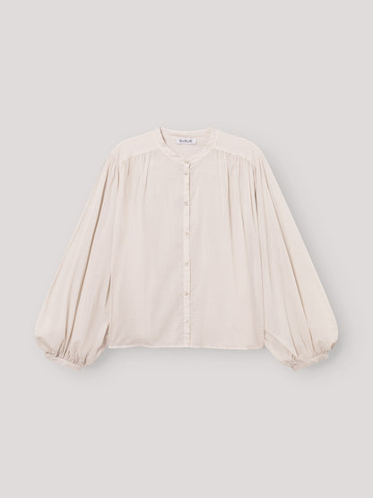 Die Bluse Bella Beige ist eine lockere, übergroße cremefarbene Bluse mit langen, weiten Ärmeln, Rundhalsausschnitt, Knopfleiste, gerafften Schultern und elastischen Bündchen - ideal als elegante Damenbluse Beige für stilvollen Komfort.