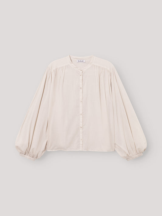 Die Bluse Bella Beige ist eine lockere, übergroße cremefarbene Bluse mit langen, weiten Ärmeln, Rundhalsausschnitt, Knopfleiste, gerafften Schultern und elastischen Bündchen - ideal als elegante Damenbluse Beige für stilvollen Komfort.