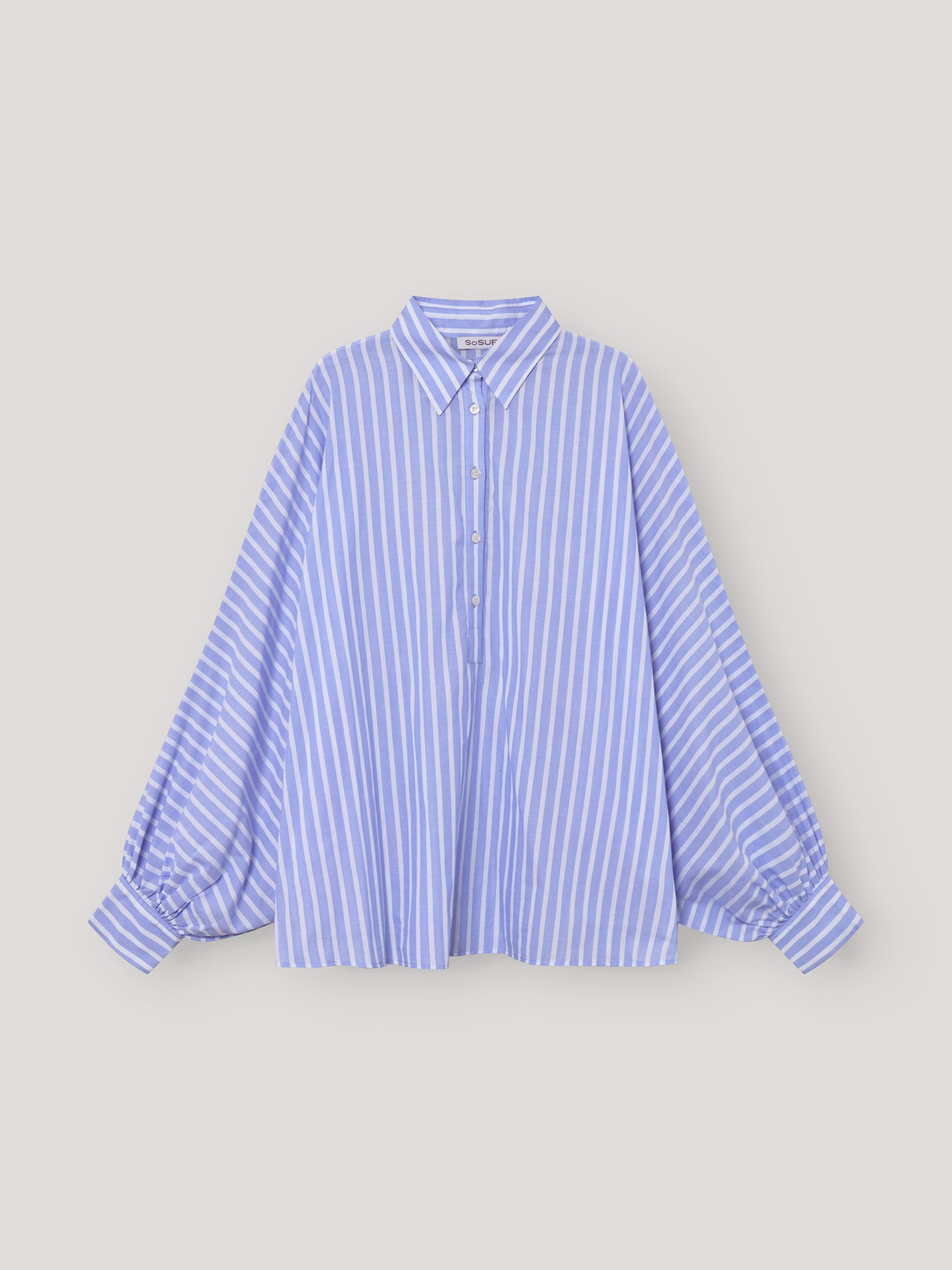 Die Oversized Damenbluse Polo Antonia stripes blue mit blau-weißen Streifen, klassischem Kragen und gerafften Manschettenärmeln präsentiert sich im schlichten Polo Stripes-Stil.