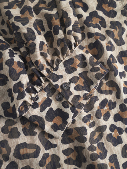 Eine Nahaufnahme des Bluse Antonia Short Sleeve Leo Ärmels mit einem stilvollen beige, braunen und schwarzen Tierprint. Die 3/4-lange Manschette wird mit zwei schwarzen Knöpfen geschlossen.