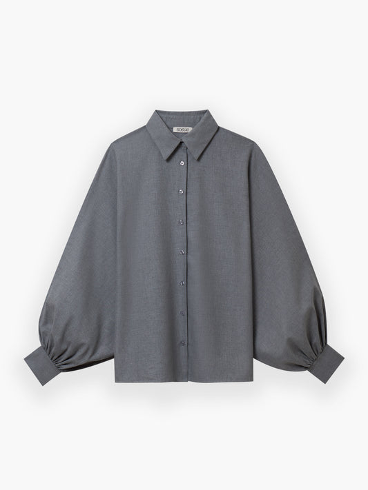 Die Bluse Antonia Grey Flanell ist eine locker sitzende, langärmelige Bluse mit spitzem Kragen, Button-Down-Front und breiten, gerafften Manschetten in luxuriöser Baumwollqualität auf weißem Grund.