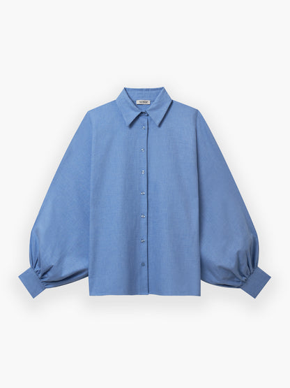 Das Bluse Antonia Flanell Light blue ist ein Button-up-Hemd mit spitzem Kragen und übergroßen, an den Manschetten gerafften Ballonärmeln, das auf einem einfarbig weißen Hintergrund gezeigt wird.