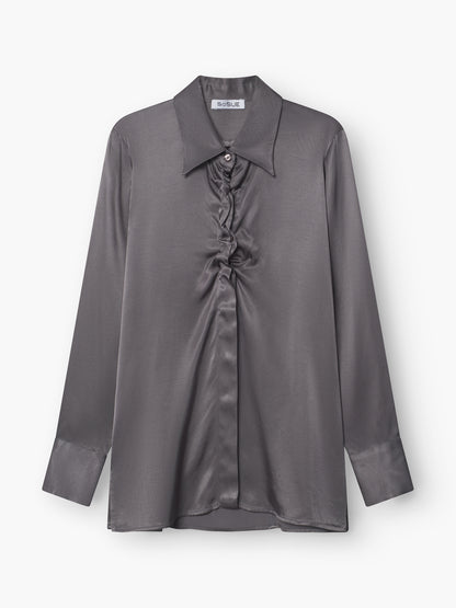 Die Bluse Ella Shiny Grey ist eine graue Satin-Langarmbluse mit spitzem Kragen, mittiger Raffung und geknöpften Manschetten, präsentiert vor weißem Hintergrund.