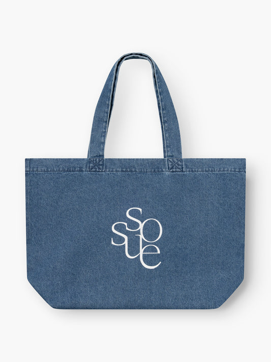 Der SOSUE Shopper Denim ist eine blaue Denim-Tasche mit zwei Henkeln und dem Schriftzug SOSUE" in weißen, stilisierten Buchstaben auf der Vorderseite - perfekt, um die Dinge des Alltags stilvoll zu transportieren.