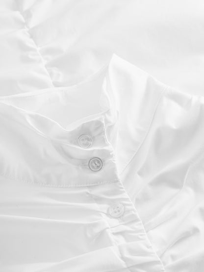 Nahaufnahme der Bluse Virginy white, eine elegante Damenbluse mit Stehkragen und drei weißen Knöpfen, leicht gekräuseltem Stoff und sanfter Beleuchtung, die die glatte Textur betont.