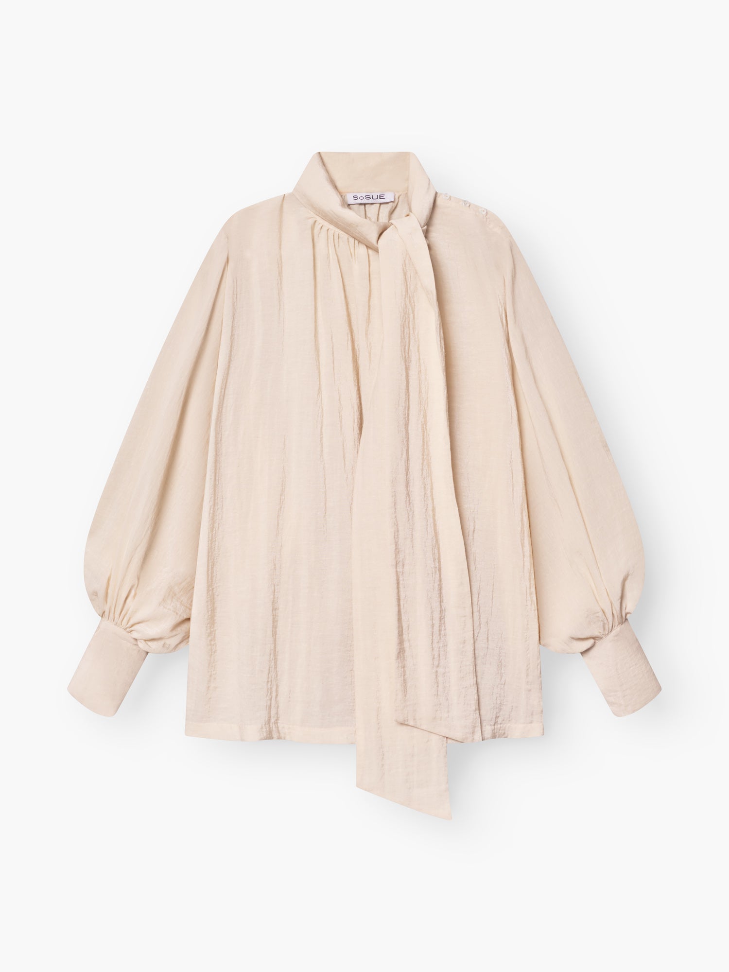 Die Bluse Bombay beige begeistert mit Schleifenkragen, langen Ballonärmeln und lockerer Passform. Ein langer, drapierter Schal am hohen Ausschnitt setzt die leicht strukturierte Qualität elegant in Szene.