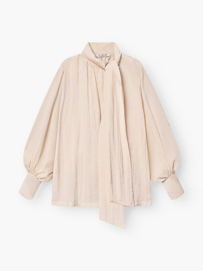 Die Bluse Bombay beige begeistert mit Schleifenkragen, langen Ballonärmeln und lockerer Passform. Ein langer, drapierter Schal am hohen Ausschnitt setzt die leicht strukturierte Qualität elegant in Szene.