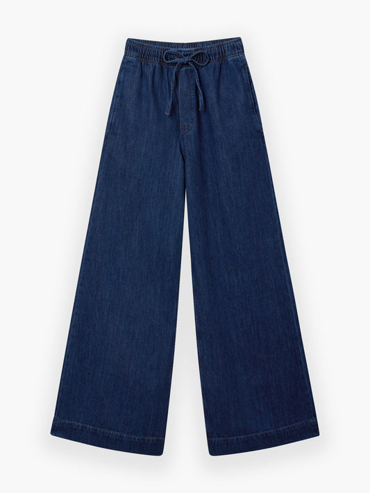 Die Pants Anna Dark Blue bieten eine weite Passform mit elastischem Bund, Kordelzug und Seitentaschen in stylischer Denim-Optik, die flach auf weißem Grund liegt.