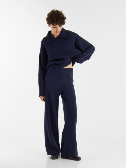 Eine Frau in einem blauen Pullover und einer Hose Merino Darklblue.