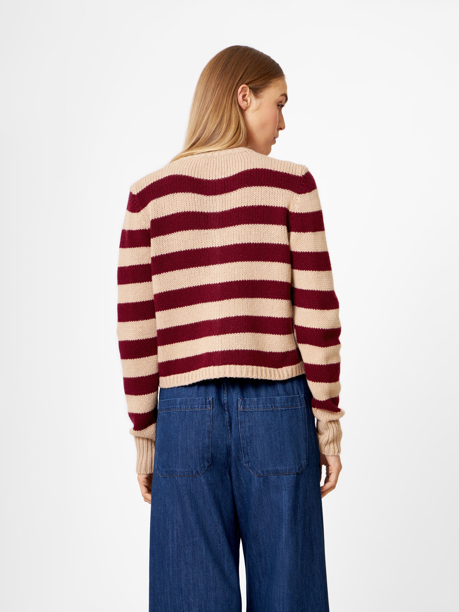 Eine Person mit langem, hellbraunem Haar wird von hinten gezeigt. Sie trägt ein Jacket Stripe Burgundy Stripe und eine weit geschnittene Bluejeans vor einem schlichten weißen Hintergrund.