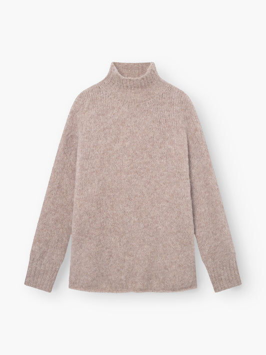 Der Pullover Liv Turtle Beige ist ein hellbeiger Rollkragenpullover mit langen Ärmeln, weicher, flauschiger Textur und gerippten Bündchen und Halsausschnitt, der flach auf weißem Grund liegt und einen gemütlichen Look bietet.