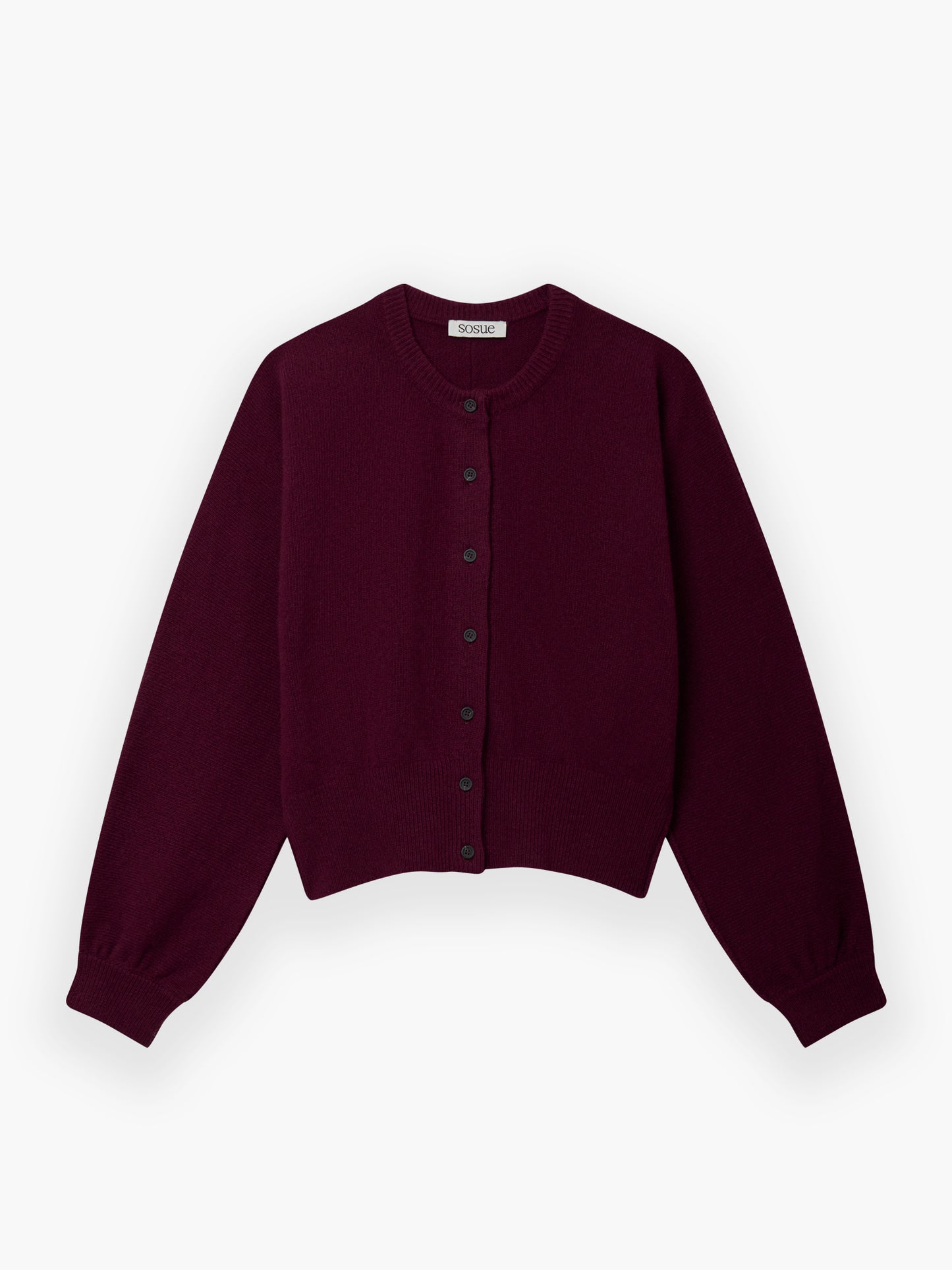 Die Strickjacke Charlotte Burgundy ist eine kurz geschnittene, langärmelige Strickjacke mit rundem Ausschnitt und schwarzen Knöpfen auf der Vorderseite, die flach auf weißem Grund liegt.