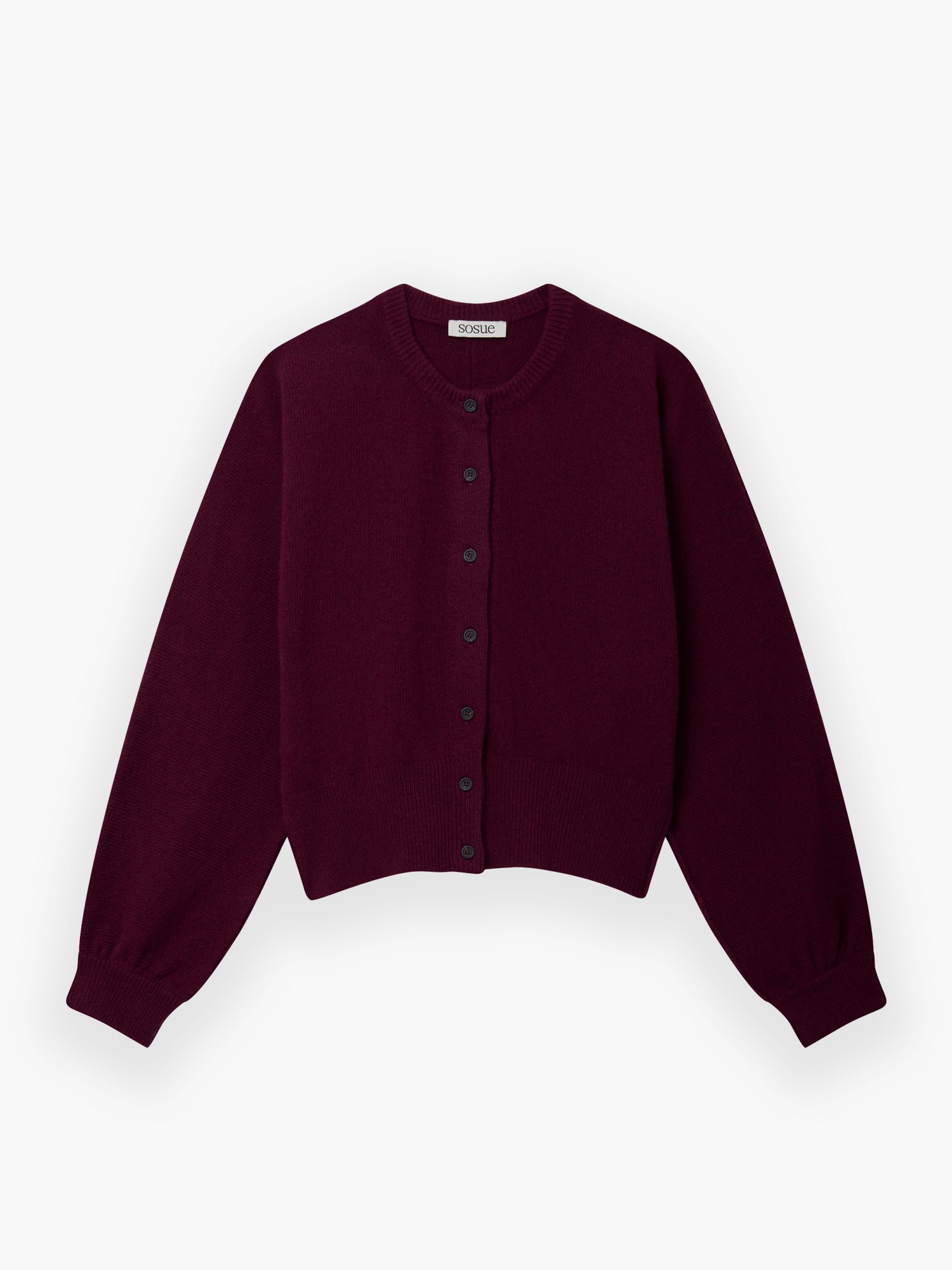 Die Strickjacke Charlotte Burgundy ist eine kurz geschnittene, langärmelige Strickjacke mit rundem Ausschnitt und schwarzen Knöpfen auf der Vorderseite, die flach auf weißem Grund liegt.