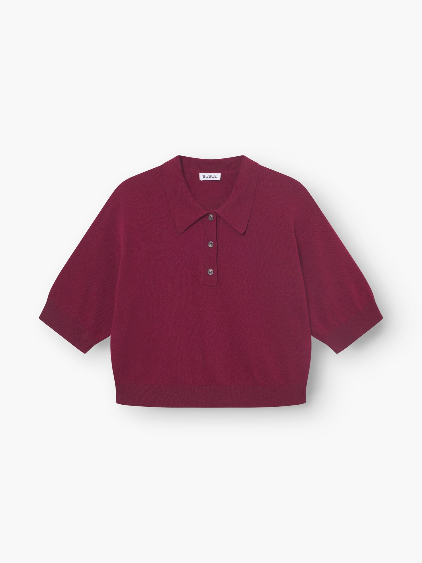 Ein weinrotes Pullover-Polo für Damen mit kurzen Ärmeln, breitem Kragen und Drei-Knopf-Knopfleiste, flach auf weißem Grund abgebildet.