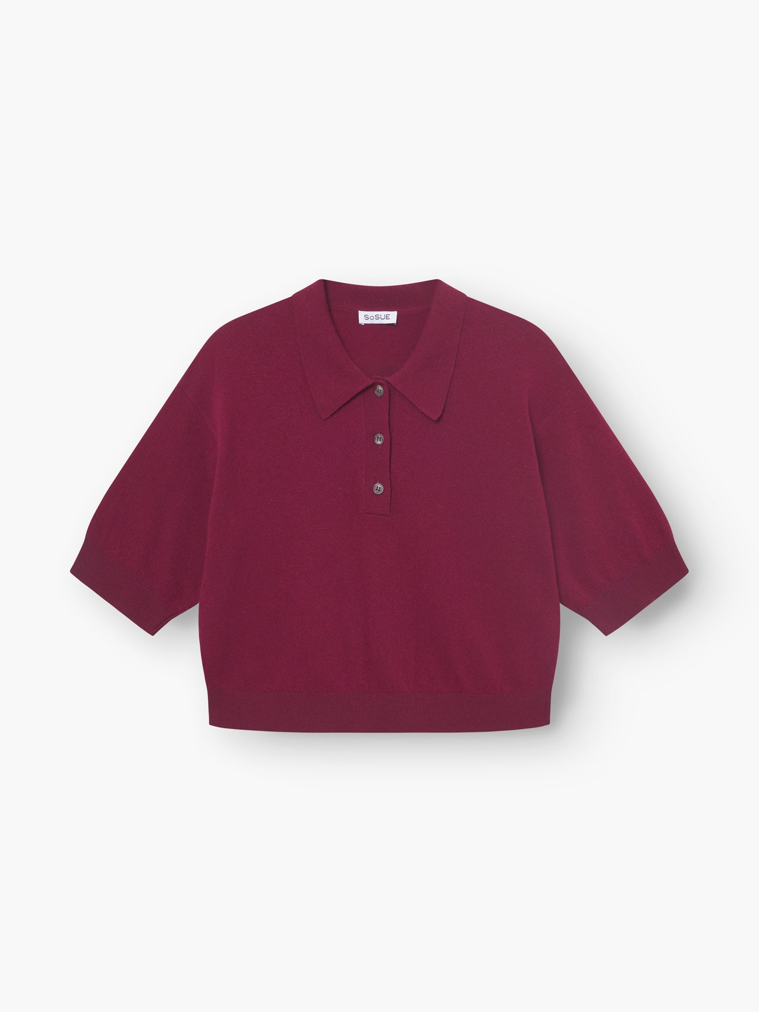 Ein weinrotes Pullover-Polo für Damen mit kurzen Ärmeln, breitem Kragen und Drei-Knopf-Knopfleiste, flach auf weißem Grund abgebildet.