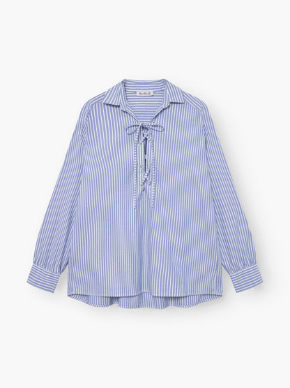 Die Bluse Fisherman Light Blue Stripes hat blaue und weiße Längsstreifen, einen Kragen, eine Schnürung vorne und lange Ärmel. Es besteht aus 100% Baumwolle und ist auf einem weißen Hintergrund abgebildet.