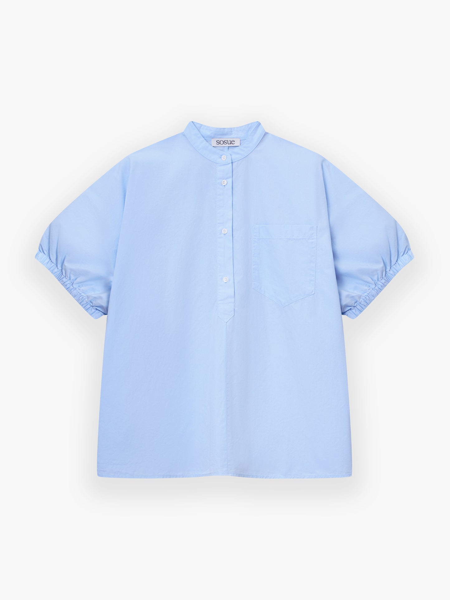 Das Cowboy Button Cotton Light Blue ist ein kurzärmeliges Hemd mit Stehkragen, partieller Knopfleiste, einer Brusttasche und gerollten Manschetten in Hellblau auf weißem Hintergrund.