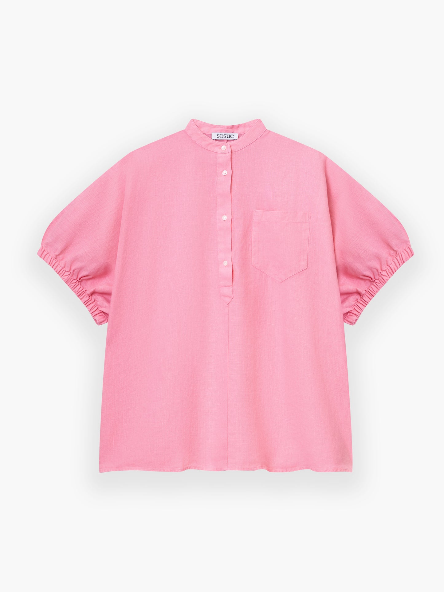 Das Cowboy Button Linen Pink ist ein locker sitzendes, kurzärmeliges rosa Hemd mit Stehkragen, Knopfleiste, Brusttasche und gerafften Ärmelsäumen, abgebildet auf weißem Hintergrund.