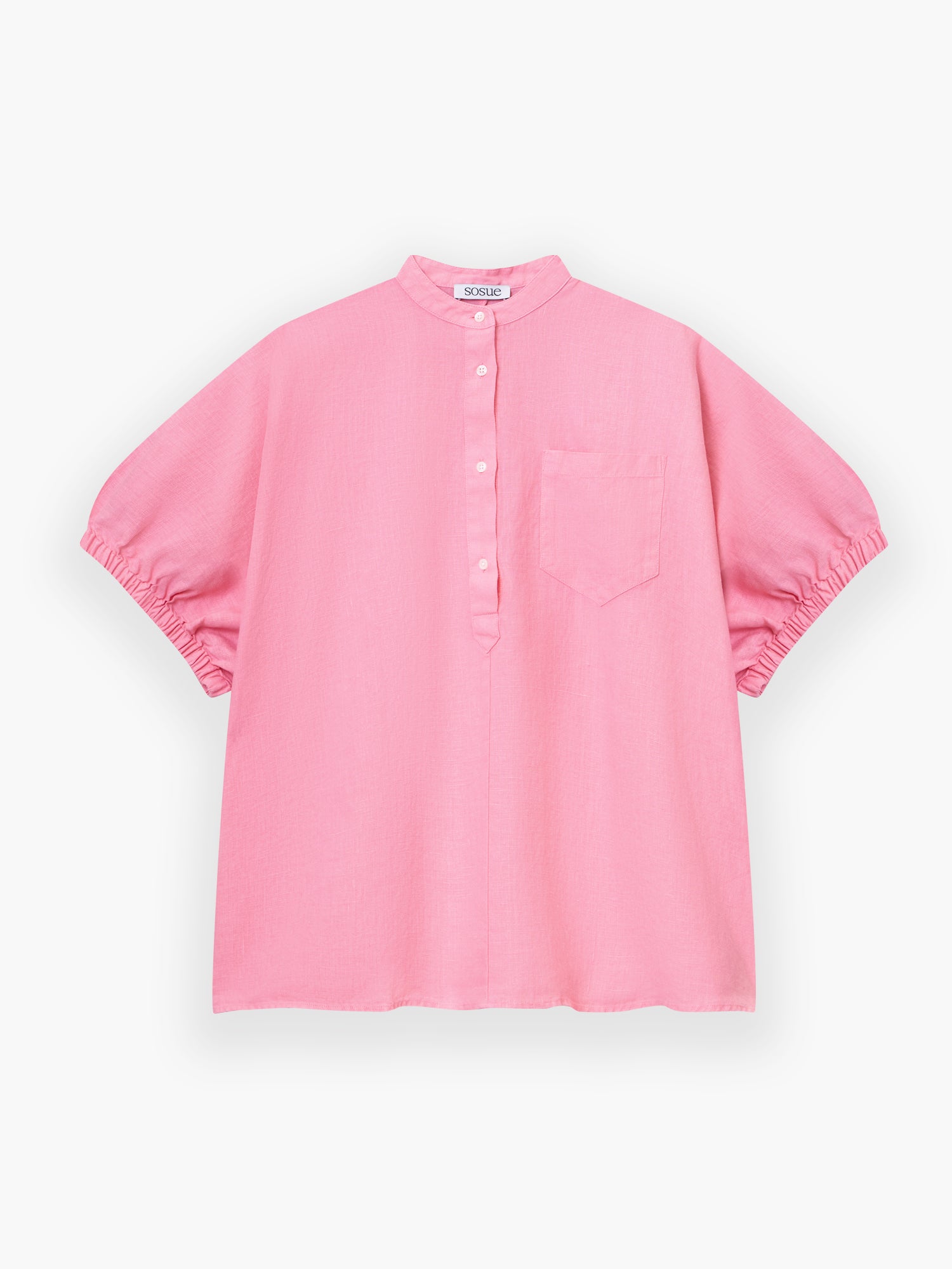 Das Cowboy Button Linen Pink ist ein locker sitzendes, kurzärmeliges rosa Hemd mit Stehkragen, Knopfleiste, Brusttasche und gerafften Ärmelsäumen, abgebildet auf weißem Hintergrund.