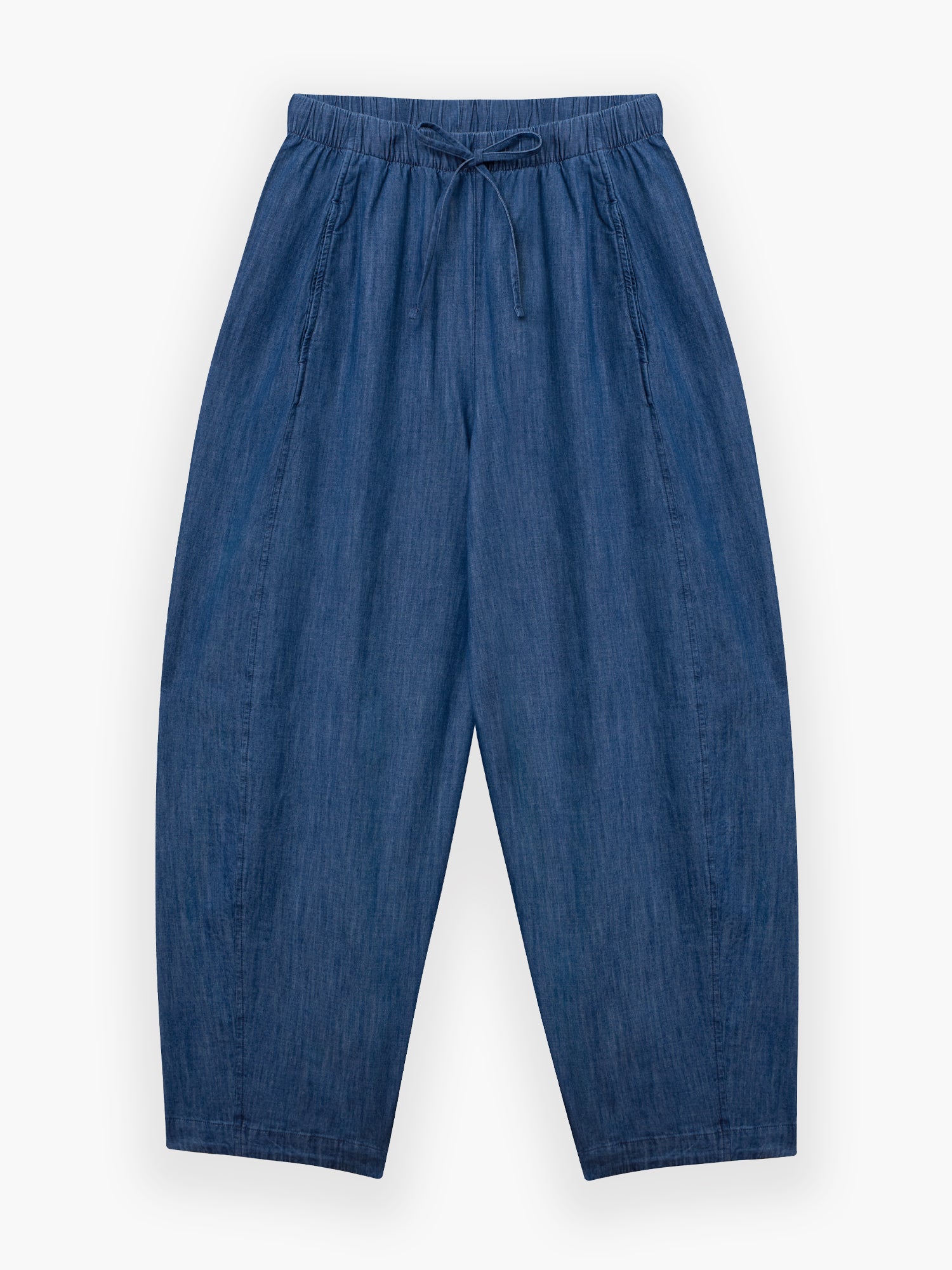 Die Lizzy Denim Hose ist locker geschnitten, hat einen elastischen Bund mit Kordelzug und ist aus leichtem Denim gefertigt. Diese übergroße Hose mit weitem Bein ist flach auf weißem Grund abgebildet.