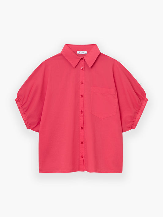 Das Cowboy Collar Voile Red ist ein leuchtend rosafarbenes, kurzärmeliges Button-up-Hemd mit Kragen und einer Brusttasche, das auf einem einfarbig weißen Hintergrund abgebildet ist.