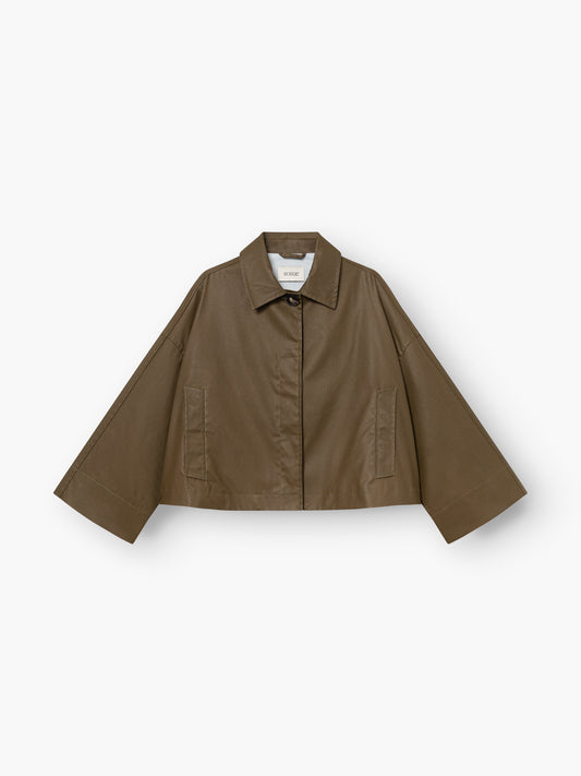 Der Dog Walker Coat ist eine kurz geschnittene braune Jacke im Utility-Stil mit weiten Ärmeln, einem spitzen Kragen, einer Knopfleiste und zwei Vordertaschen, abgebildet auf weißem Hintergrund.