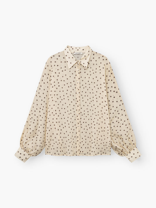 Die Bluse „Antonia Polka Dots Ecru Brown“, hergestellt in Italien, verfügt über einen Kragen, eine Knopfleiste vorne und braune Polka-Dots. Weicher Baumwollvoile und leicht ausgestellte Ärmel mit geknöpften Manschetten sorgen für Stil und Tragekomfort.