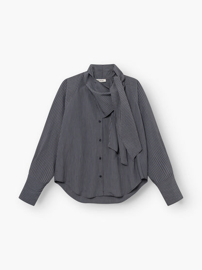Wir präsentieren die „Bluse Scarf Stripes“: eine langärmelige Damenbluse mit Knopfleiste und feinen weißen Streifen auf dunklem Stoff. Diese Streifenbluse mit Schaldetail besticht durch eine lockere Passform, weite Manschetten und ein gebundenes Schaldetail am Halsausschnitt. Wunderschön verarbeitet und „Made in Italy“.