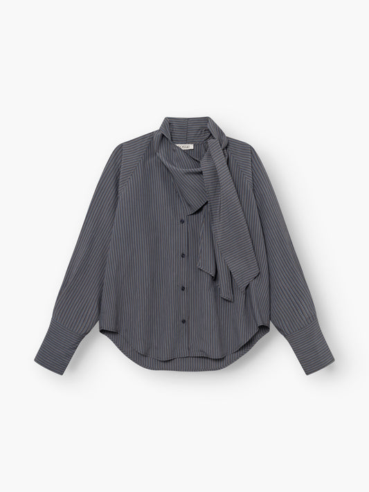 Wir präsentieren die „Bluse Scarf Stripes“: eine langärmelige Damenbluse mit Knopfleiste und feinen weißen Streifen auf dunklem Stoff. Diese Streifenbluse mit Schaldetail besticht durch eine lockere Passform, weite Manschetten und ein gebundenes Schaldetail am Halsausschnitt. Wunderschön verarbeitet und „Made in Italy“.