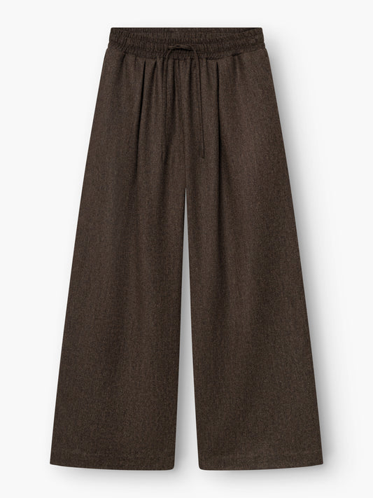 Weit geschnittene Hose „Josy Braun“ mit hoher Taille aus einer dunkelbraunen Wollmischung, mit elastischem Bund und Kordelzug, flach auf weißem Hintergrund präsentiert. Diese stilvolle braune Damenhose wird in Portugal fachmännisch gefertigt und überzeugt durch außergewöhnliche Qualität und Tragekomfort.