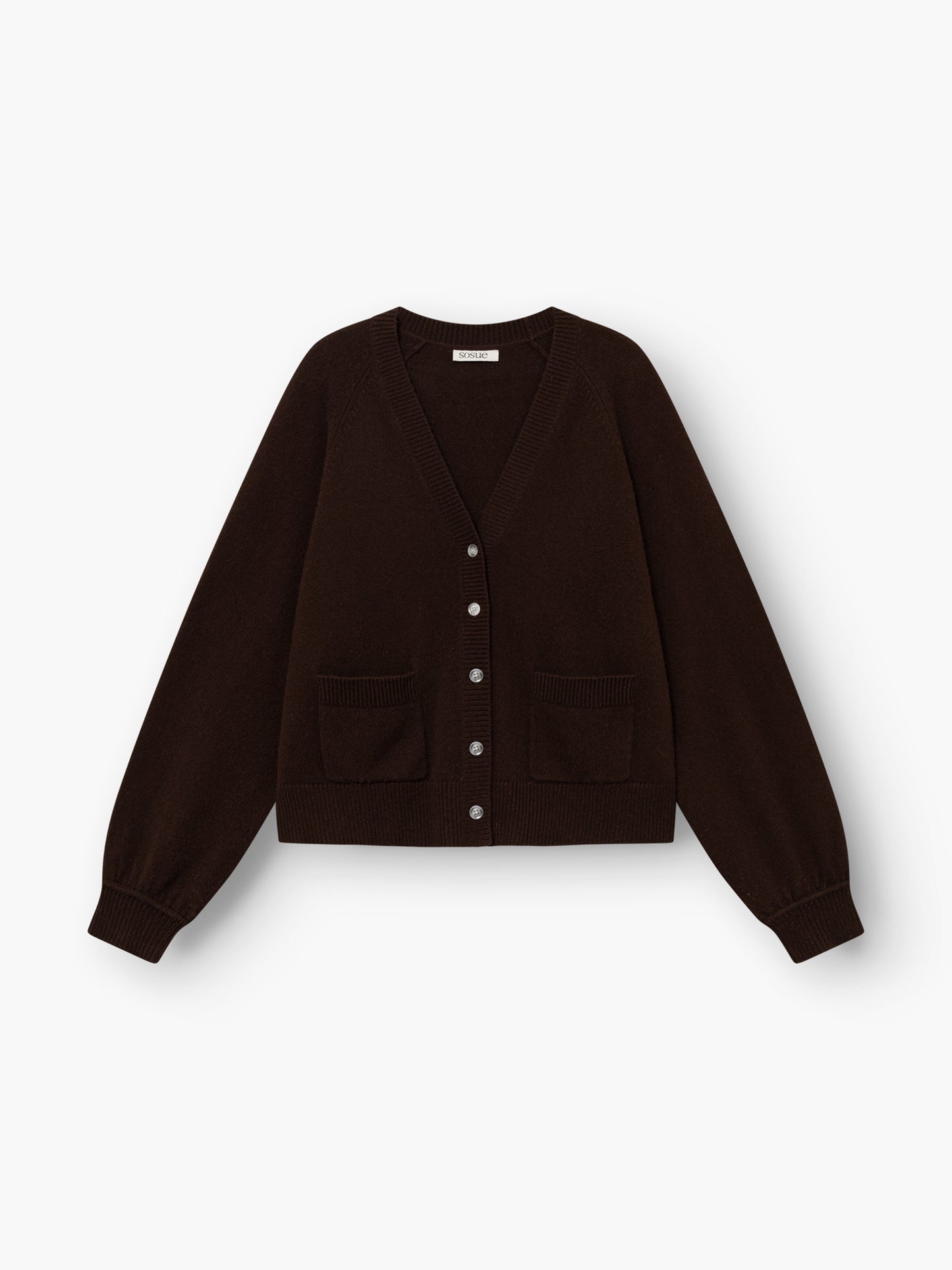 Die Bella Cardigan Braun ist eine dunkelbraune, langärmelige Strickjacke mit V-Ausschnitt, Knopfleiste vorne, zwei Vordertaschen sowie gerippten Bündchen und Saum, abgebildet auf weißem Hintergrund.