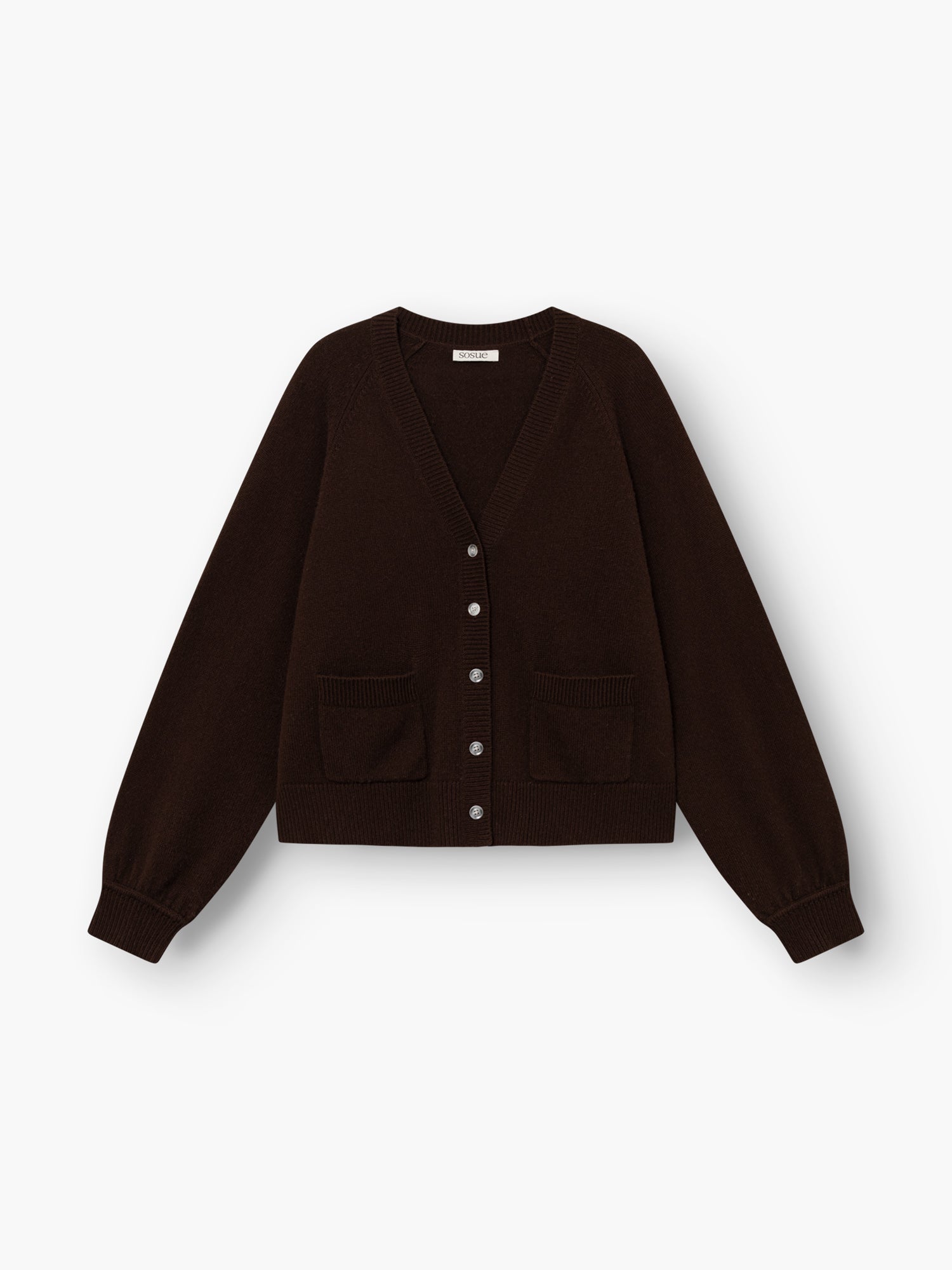 Die Bella Cardigan Braun ist eine dunkelbraune, langärmelige Strickjacke mit V-Ausschnitt, Knopfleiste vorne, zwei Vordertaschen sowie gerippten Bündchen und Saum, abgebildet auf weißem Hintergrund.