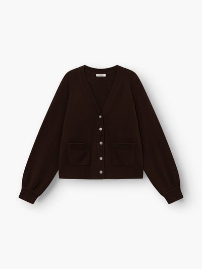 Die Bella Cardigan Braun ist eine dunkelbraune, langärmelige Strickjacke mit V-Ausschnitt, Knopfleiste vorne, zwei Vordertaschen sowie gerippten Bündchen und Saum, abgebildet auf weißem Hintergrund.
